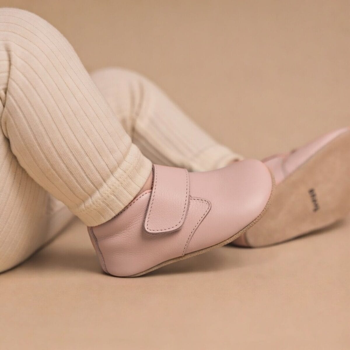 Baby shoes in dusky pink designed by Pretty Brave, featuring a soft, cozy boot style for infants.
