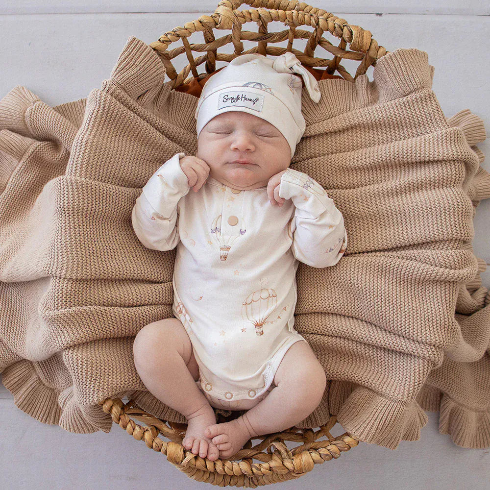 Boy wearing Snuggle Hunny Kids Up & Away long sleeve organic bodysuit, soft, comfortable boys onesie with playful print.