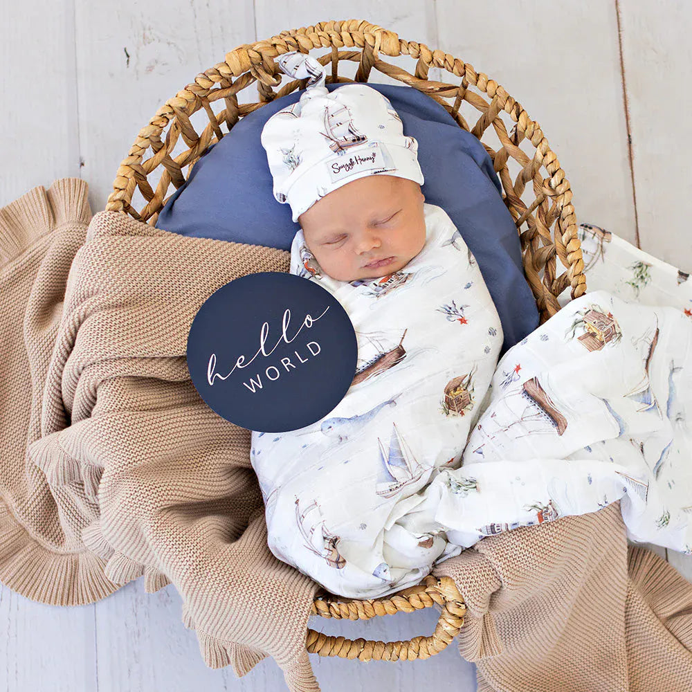 Snuggle Hunny Kids Set Sail organic muslin wrap with linen sheets featuring nautical sailboat print and soft, breathable fabric.