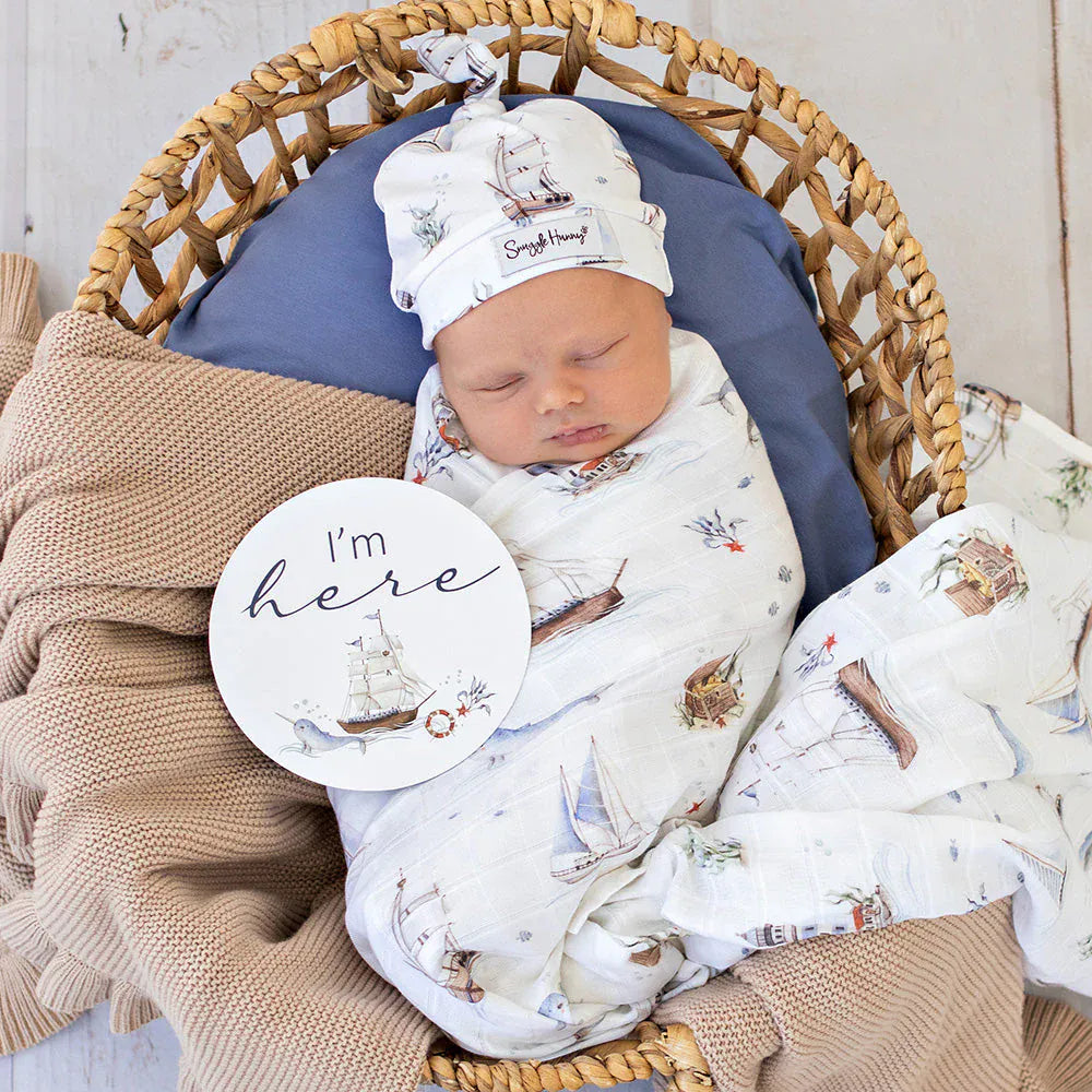 Snuggle Hunny Kids Set Sail organic muslin wrap with linen sheets featuring nautical sailboat pattern for baby bedding and wrapping.