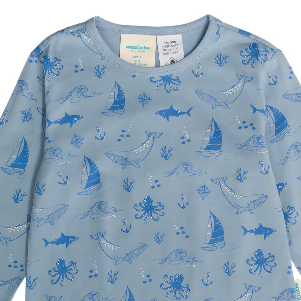 Unisex Woolbabe Merino and organic cotton winter pajamas in Glacier Sail Away pattern, soft and cozy sleepwear for cold nights.