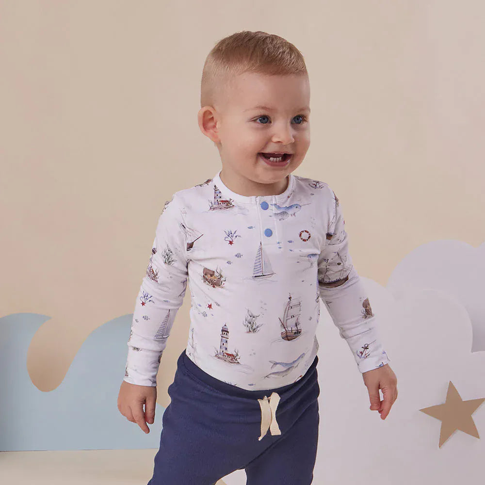 Snuggle Hunny Kids boys long sleeve organic bodysuit with sailboat print, soft cotton onesie for babies and toddlers.