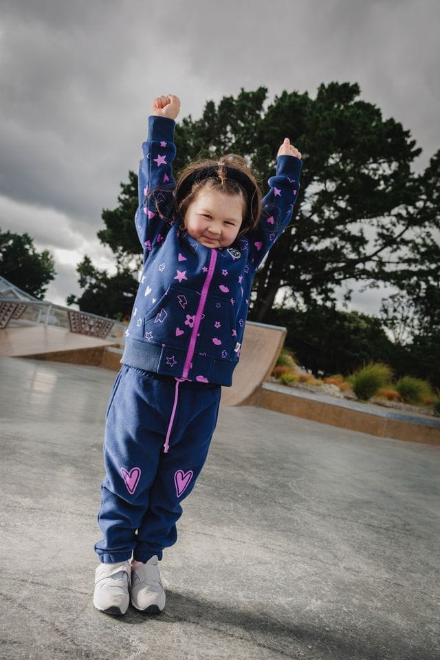 Navy icons zip hood girls jumper by The Girl Club, featuring a cozy hood and playful icon designs on soft fabric.
