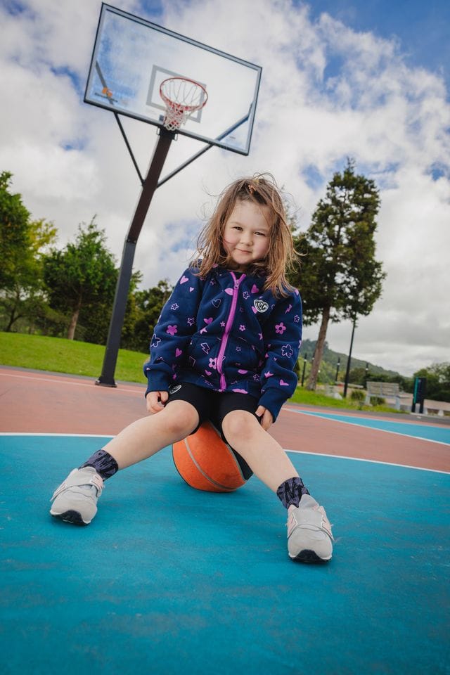 Navy girls' zip hoodie with icon designs from The Girl Club, featuring a front zipper and cozy hood.