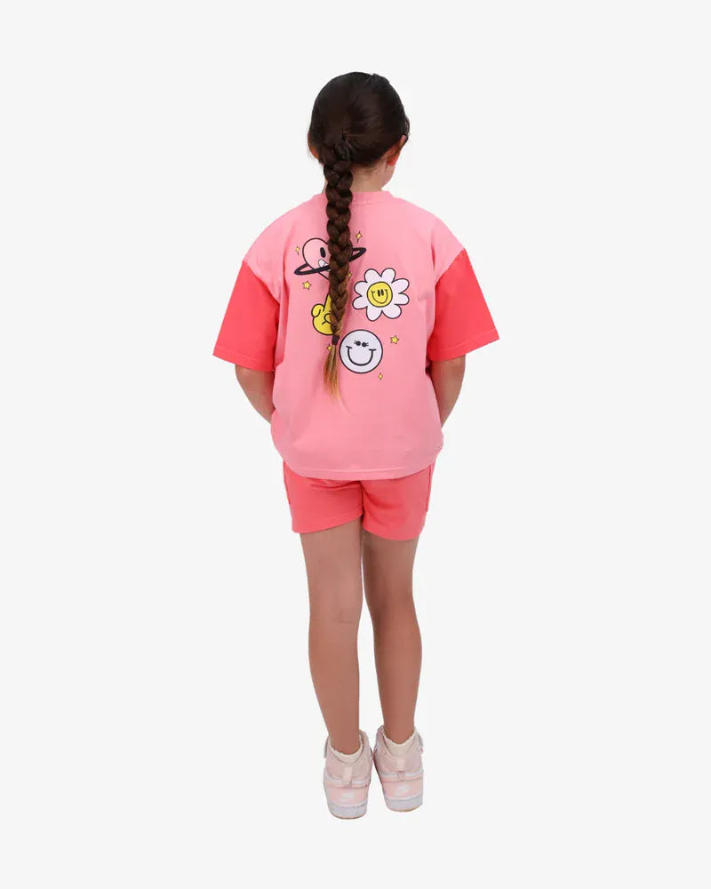 Coral girls' top featuring happy icon graphics from The Girl Club, casual and comfortable for everyday wear.
